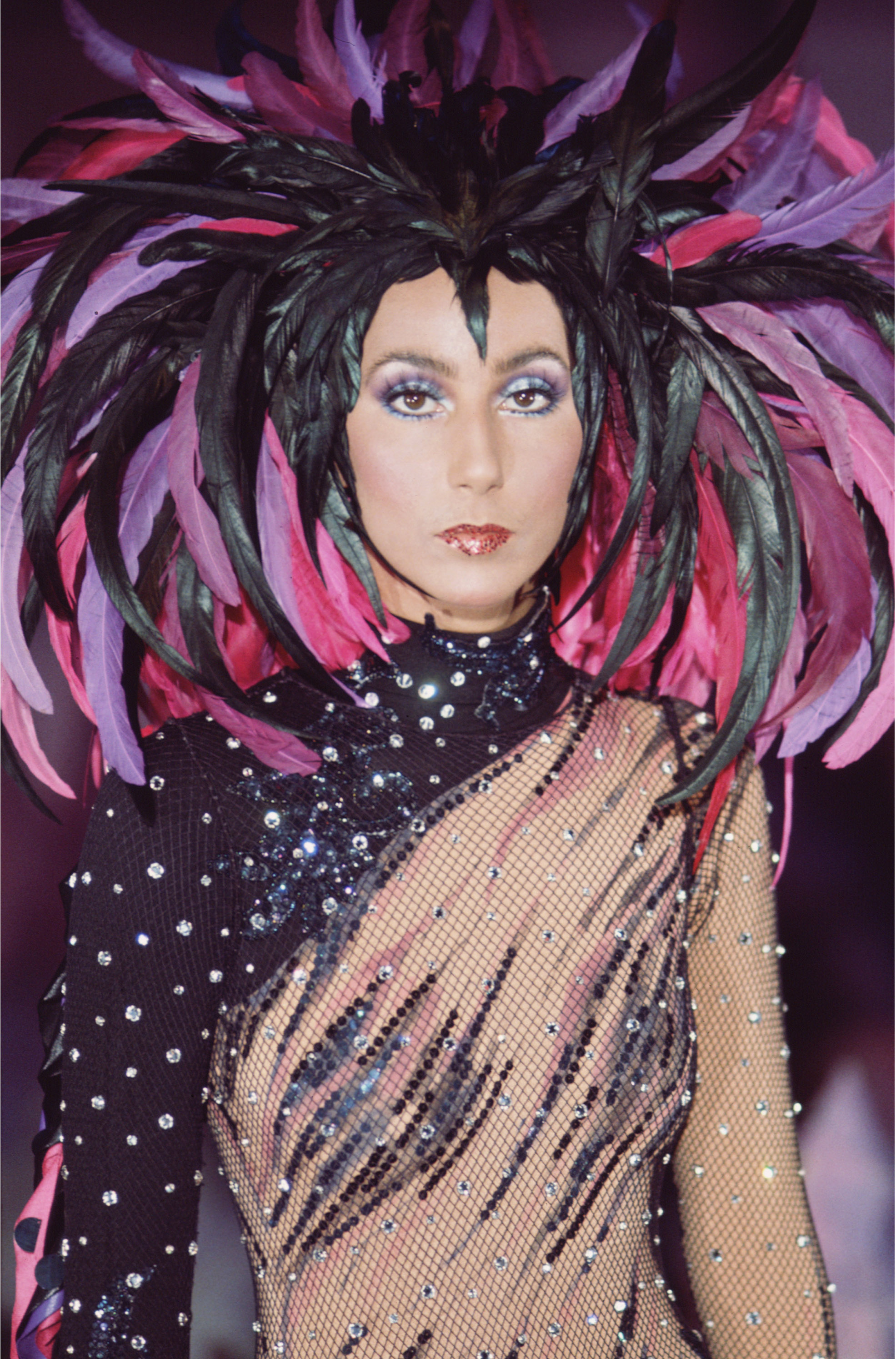 Promotional portrait of American singer and actress Cher (born Cherilyn Sarkisian LaPiere) in a semi-transparent outfit with a feathered headdress for the television variety show 'The Sonny and Cher Comedy Hour,' 1972. (Photo by CBS Photo Archive/Getty Images)